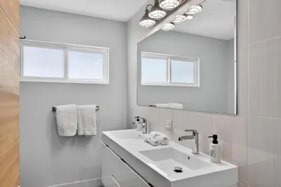 a white bathroom with a sink and a mirror at Your Coastal Getaway in Manhattan Beach Awaits in Manhattan Beach