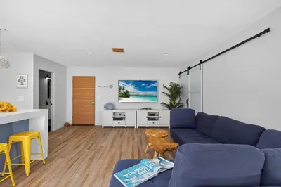 a living room with a blue couch and a kitchen at Your Coastal Getaway in Manhattan Beach Awaits in Manhattan Beach