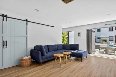 a living room with a blue couch and a table at Your Coastal Getaway in Manhattan Beach Awaits in Manhattan Beach