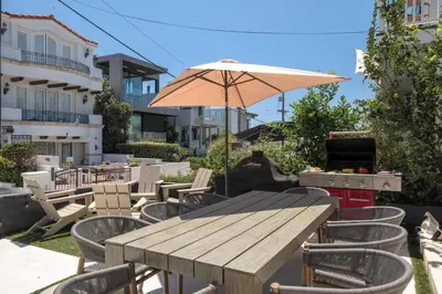a wooden table and chairs with an umbrella at Your Coastal Getaway in Manhattan Beach Awaits in Manhattan Beach