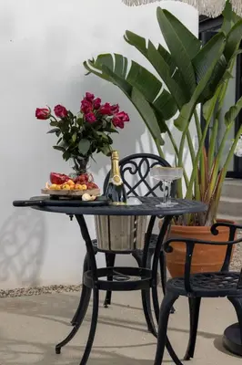 a table with a vase of flowers and a bottle of champagne at Luxe 2BR with Designer Touches, Walk to Everything in Los Angeles