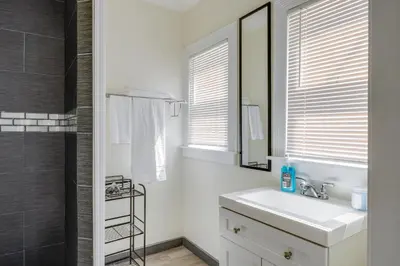 a white bathroom with a sink and a mirror at Walk to Dtwn Tehachapi Updated Getaway with Yard! in Tehachapi