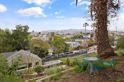 a table and chairs sitting under a tree on a hill at New Listing Hillside Villa by Colby & Conrad in Los Angeles