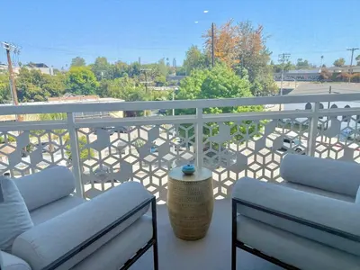 a balcony with two chairs and a railing at Designer 1 Bedroom Condo in Silver Lake in Los Angeles