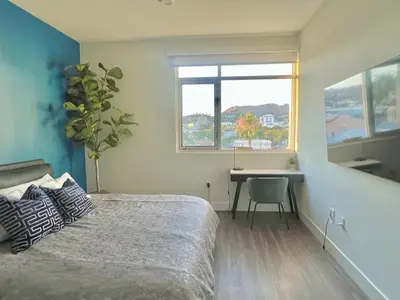 a bedroom with a bed and a desk and a window at Penthouse with Hollywood Sign View 2 Bedrooms with 3 Beds in Los Angeles