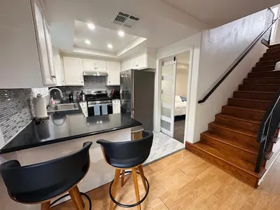 a kitchen with a black counter top and a staircase at Echo House in Los Angeles