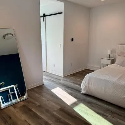 an empty bedroom with a bed and a mirror at Guesthouse in Hewitt