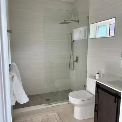 a white bathroom with a shower and a toilet at Guesthouse in Hewitt