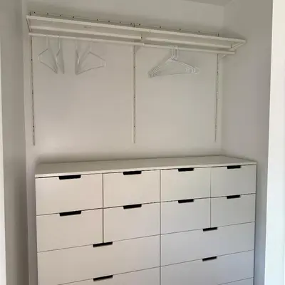 a white closet with white cabinets and hangers at Guesthouse in Hewitt
