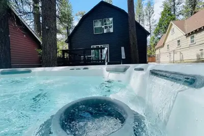 a hot tub in the snow in front of a house at The Wilderness Haven in Big Bear Lake