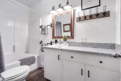 a white bathroom with a toilet sink and a mirror at The Wilderness Haven in Big Bear Lake