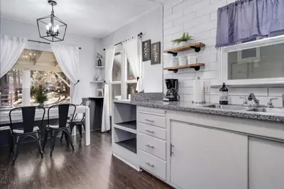 a kitchen with white cabinets and a table and chairs at The Wilderness Haven in Big Bear Lake