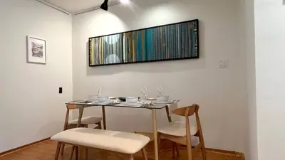 a dining room table with chairs and a television on the wall at Charming 1BR in Prime Santa Monica Walk to Beach in Los Angeles