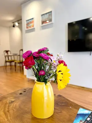 a yellow vase filled with colorful flowers on a table at Charming 1BR in Prime Santa Monica Walk to Beach in Los Angeles