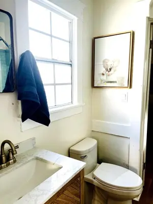 a bathroom with a toilet and a sink and a window at Cozy Hollywood Cottage - Free Parking in Los Angeles