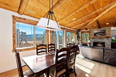 a dining room with a table and chairs and a couch at California Dreaming: Lakeside Cabin Getaway in the Best Location in San Bernardino