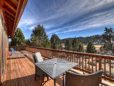 a wooden deck with a table and chairs on it at California Dreaming: Lakeside Cabin Getaway in the Best Location in San Bernardino
