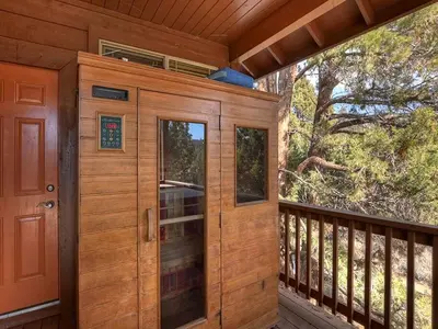 a wooden cabin with a balcony with a door at California Dreaming: Lakeside Cabin Getaway in the Best Location in San Bernardino