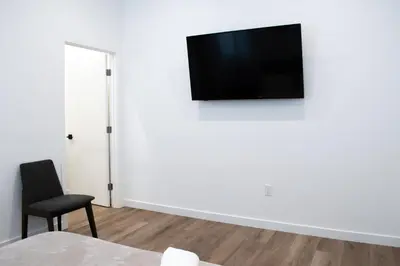 a room with a chair and a television on a wall at New 2BR Family Home Nr Universal in Gemco