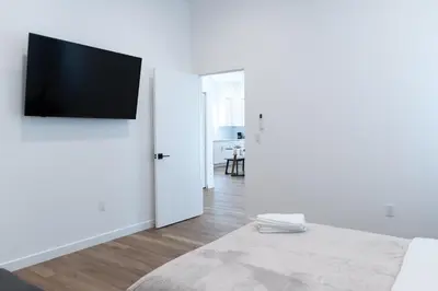 a white room with a flat screen tv on a wall at New 2BR Family Home Nr Universal in Gemco