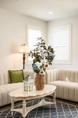 a living room with a couch and a table with a vase at Spacious 5BR Getaway w Game Room & Modern Comfort in Fontana