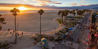 a group of people walking on the beach at sunset at Seaside 2BR with Ocean View and Roof Garden - VE3-MDR in Los Angeles