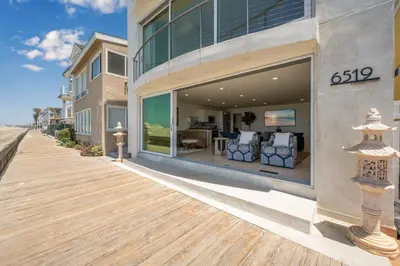 a building with a wooden boardwalk next to a house at Ocean Views in Long Beach in Long Beach