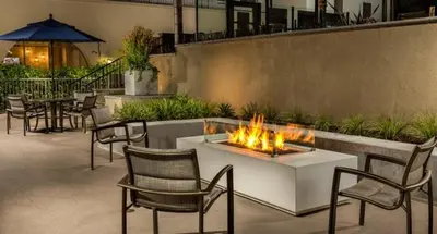 a patio with a fire pit and chairs and tables at Designer 2 Bedroom with 3 Beds- Pool View, Gym, Parking in Los Angeles
