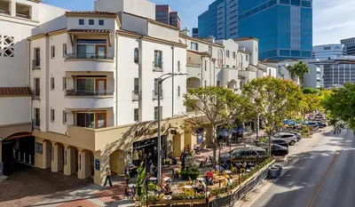 a city street with a building with people sitting outside at Designer 2 Bedroom with 3 Beds- Pool View, Gym, Parking in Los Angeles