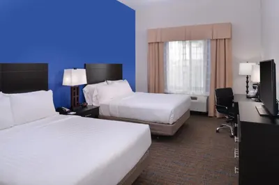 a hotel room with two beds and a desk at Holiday Inn Express & Suites Bakersfield Airport by IHG in Bakersfield