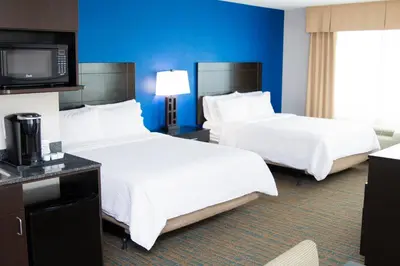 a hotel room with two beds and a flat screen tv at Holiday Inn Express & Suites Bakersfield Airport by IHG in Bakersfield