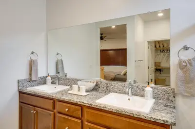a bathroom with two sinks and a large mirror at 9 Mi to Dtwn Bakersfield Pet-Friendly Home in Bakersfield