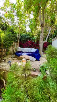 a bed in the middle of a garden with trees at Enchanting Private Hollywood Hills Guest House with Tranquil Tree-Top Views, Magical Outdoor Living Room and Patio and Zen Garden, In LA's Most Desirable, Central, Serene Area and Only 2 Minutes from Hollywood Boulevard in Los Angeles