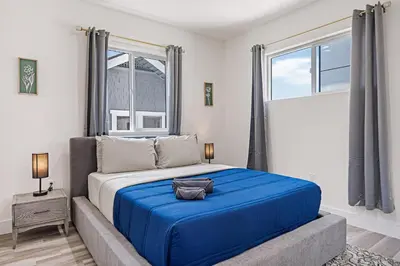 a bedroom with a large bed with a blue blanket at Sophisticated Getaway Hollywood & Dtla in Los Angeles