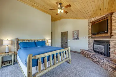 a bedroom with a bed and a tv and a fireplace at Walkable Big Bear Lake Home with Private Hot Tub! in Big Bear Lake