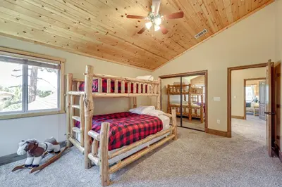 a bedroom with two bunk beds and a ceiling fan at Walkable Big Bear Lake Home with Private Hot Tub! in Big Bear Lake