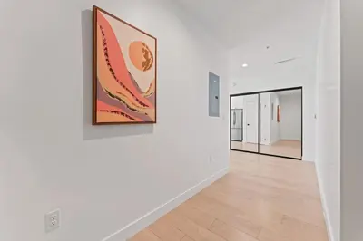 a hallway with white walls and a painting on a wall at Stylist Downtown LA Gateway- Studio Apt in Los Angeles