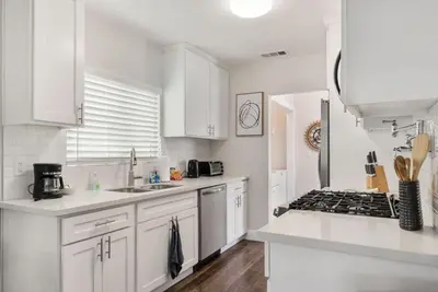 a white kitchen with white cabinets and a stove at Travel Haven - Great Location - Quiet Area in Long Beach