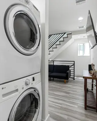a washer and dryer in a living room with a staircase at Contemporary Retreat Hollywood & DTLA in Los Angeles