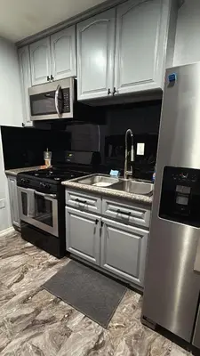 a kitchen with white cabinets and a stainless steel sink at LUXURY VILLA Estate Oasis in Downey