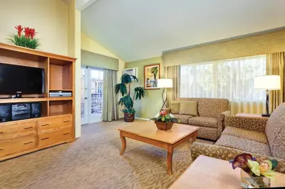 a living room with a couch and a tv at Wyndham Dolphin's Cove 2BR Suite with Resort Access in Anaheim