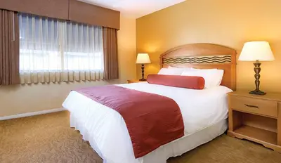 a hotel room with a large bed and a window at Wyndham Dolphin's Cove 2BR Suite with Resort Access in Anaheim