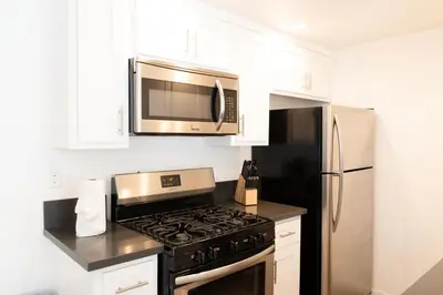 a kitchen with a stove and a microwave at Cozy Stylish 1-Bedroom In Hollywood With Free Gated Parking in Los Angeles