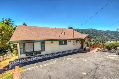 a house with a roof on top of a driveway at Best View of the Lake! Huge Deck! in Crestline