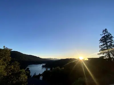 a view of the sun rising over a river at Best View of the Lake! Huge Deck! in Crestline