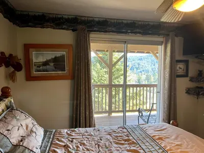 a bedroom with a bed and a sliding glass door at Best View of the Lake! Huge Deck! in Crestline