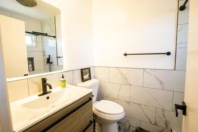 a bathroom with a sink and a toilet and a mirror at Renovated Culver City Escape Walkable WFH in Los Angeles
