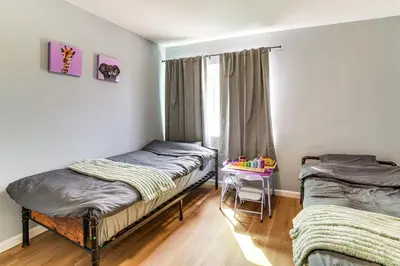 two beds in a room with a window and a table at Golf, Swim, Relax Family Retreat in Corona! in Corona