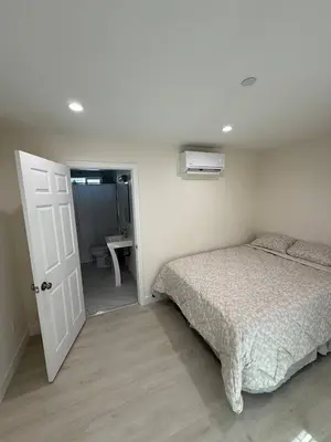 a bedroom with a bed and a door to a bathroom at San Marino guest house in Los Angeles