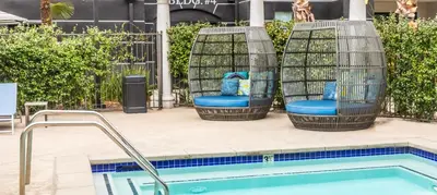 two birdcage chairs sitting next to a swimming pool at Noho Haven 2 bed Apt with FREE Parking in North Hollywood
